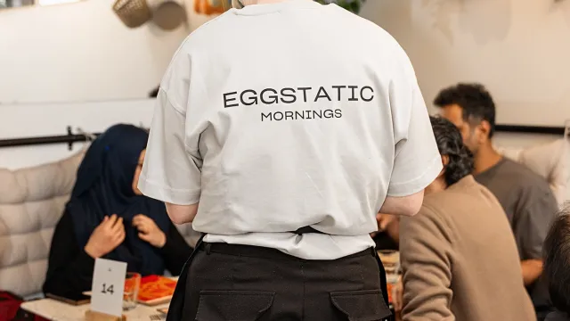 Eggstatic server in a “Mornings” tee in the dining room