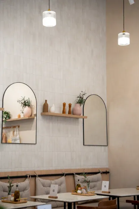 Tile wall with arched mirrors and styled shelf at Eggstatic Oakville on Winston Park Drive