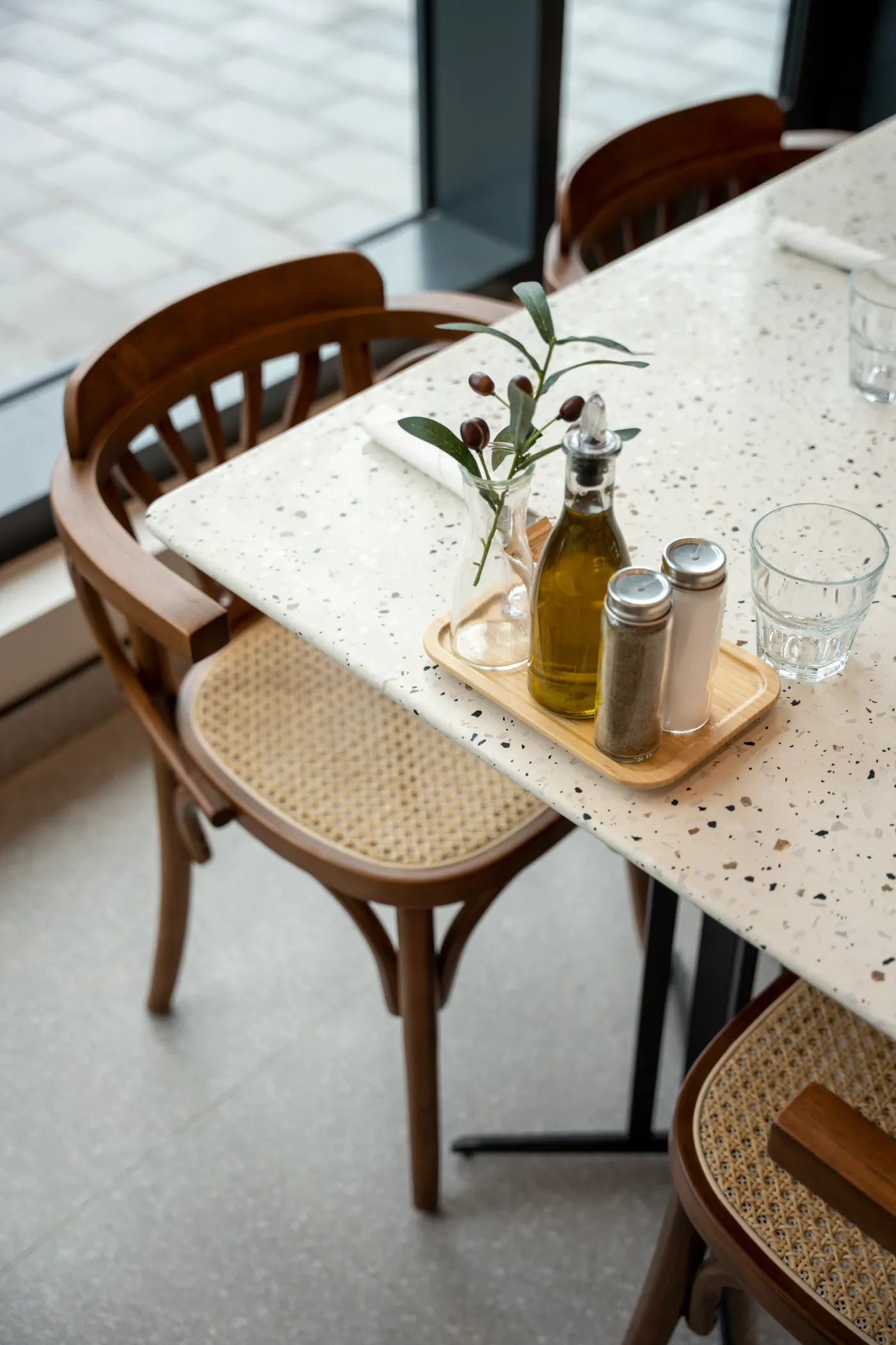 Olive oil cruet and condiments on a terrazzo table by the window at Eggstatic