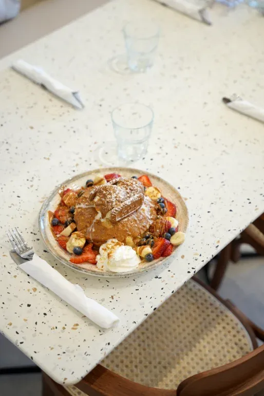 Stuffed croissant brunch plate with berries and whipped cream at Eggstatic Waterdown