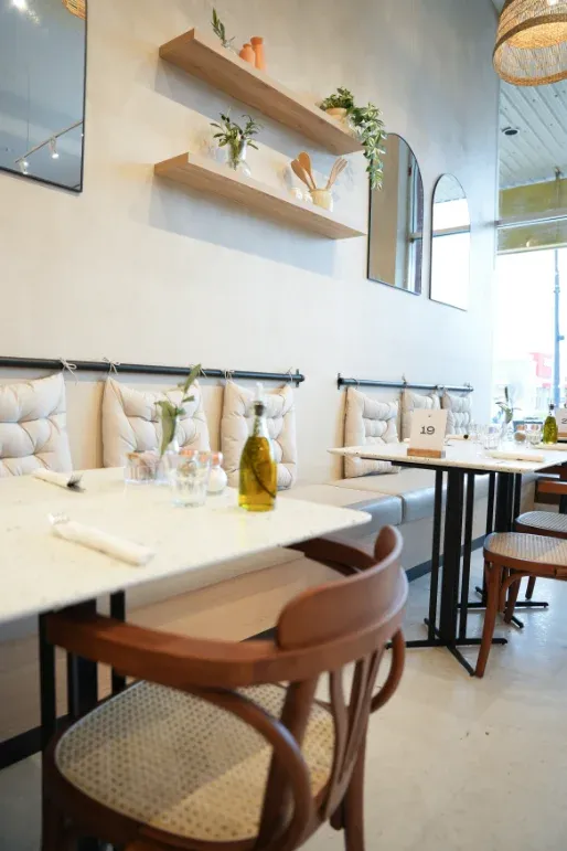 Banquette seating with marble tables and styling shelves at Eggstatic Waterdown