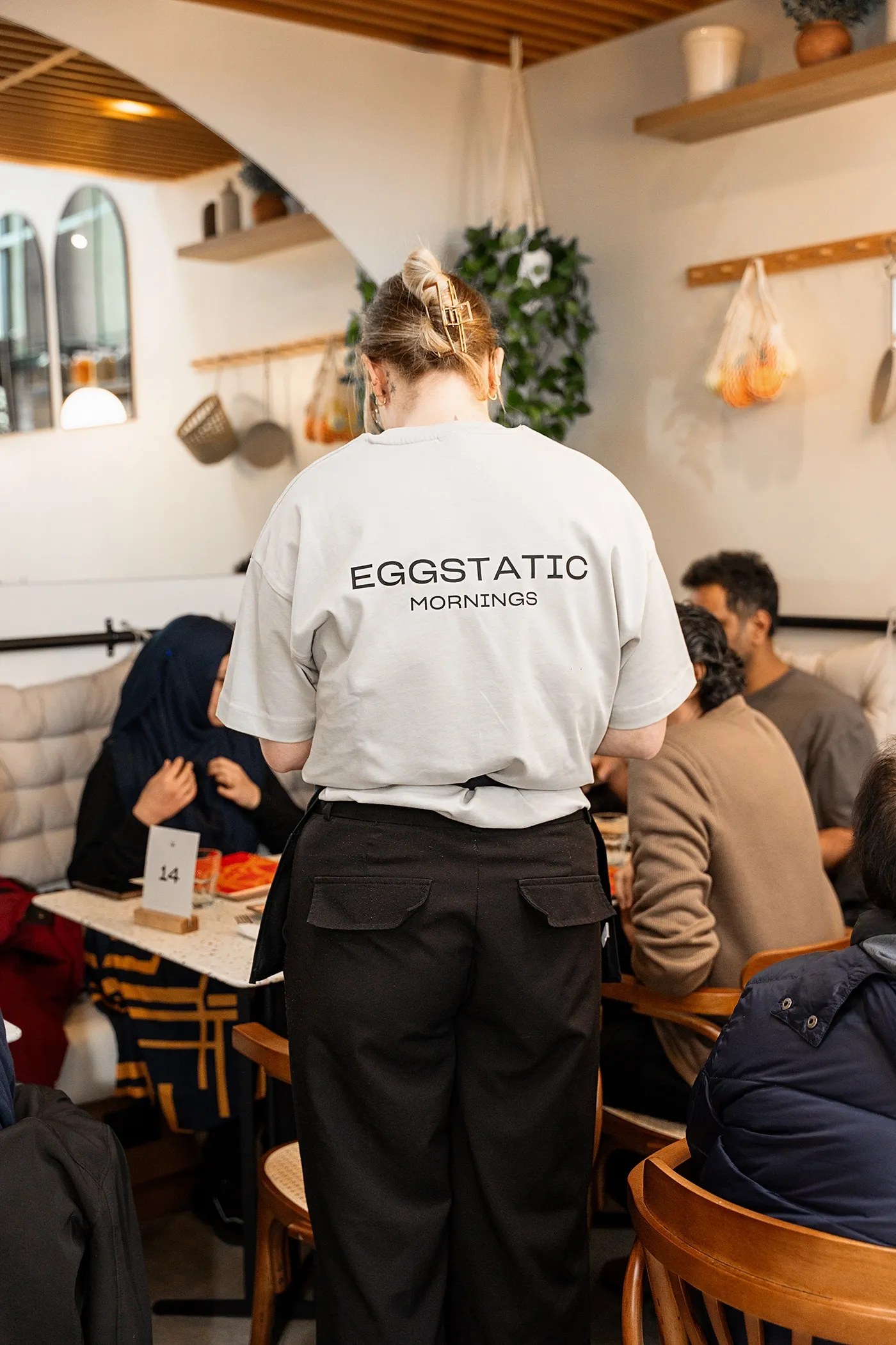 Eggstatic server in a “Mornings” tee in the dining room
