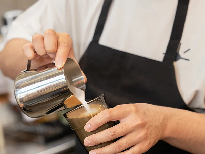 Barista pouring a latte at Eggstatic