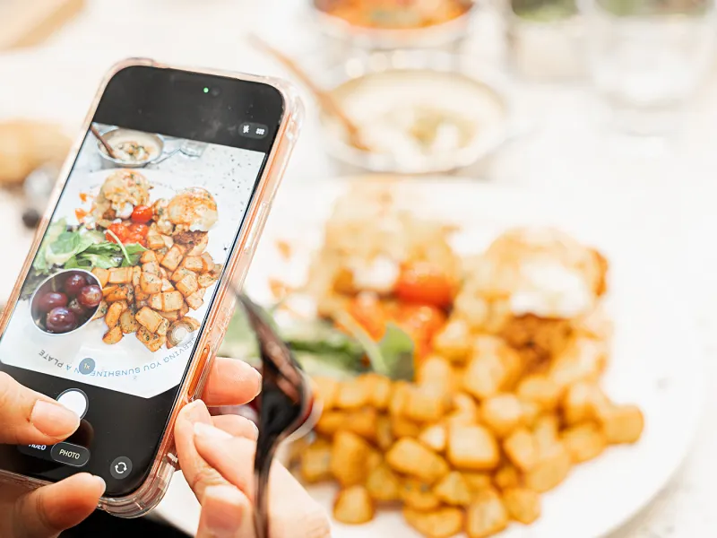 Guest photographing a brunch plate at an Eggstatic table
