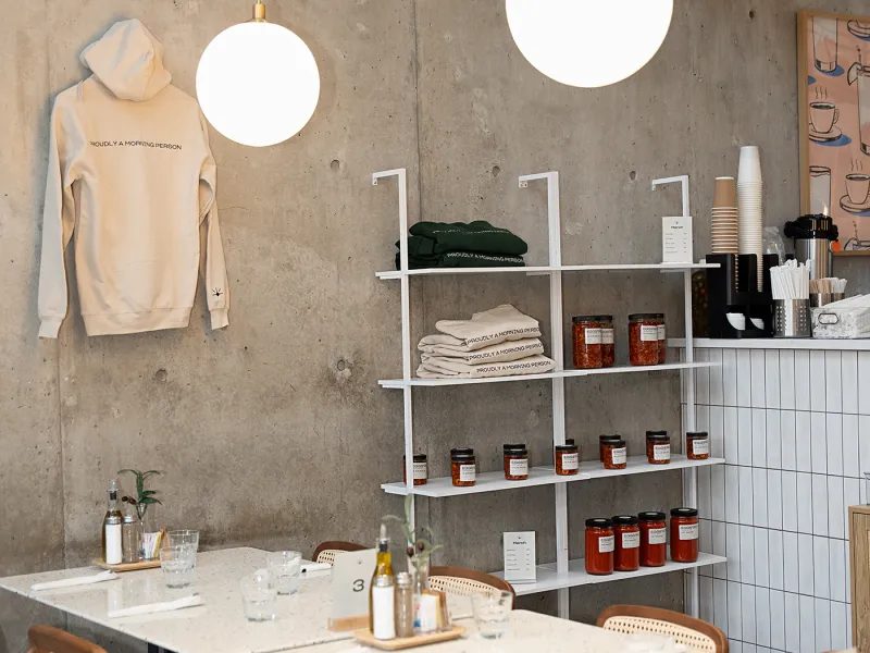 Eggstatic dining room with terrazzo tables, globe pendant lights and shelves of preserves